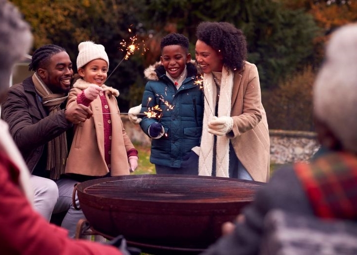 multi generation family having fun at bonfire